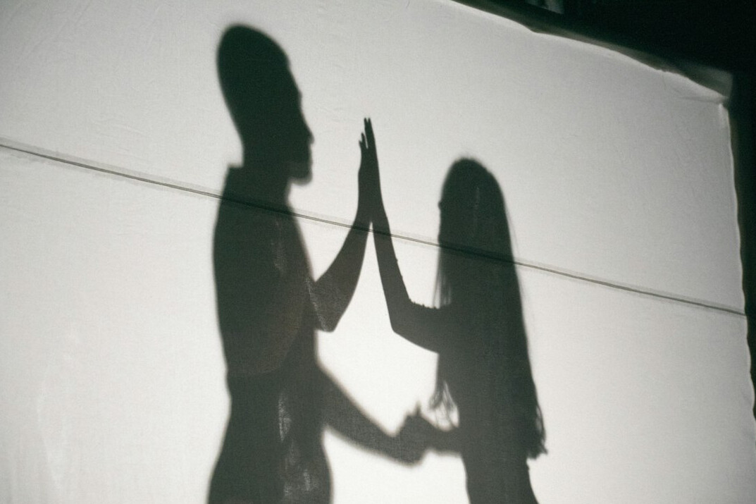 Two Brazilian colleagues shaking hands respectfully in an office